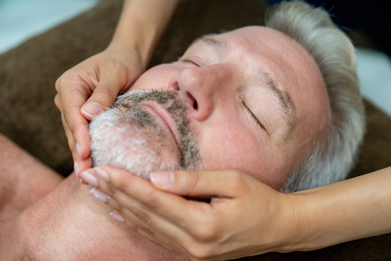 Adult man getting a facial massage at a spa