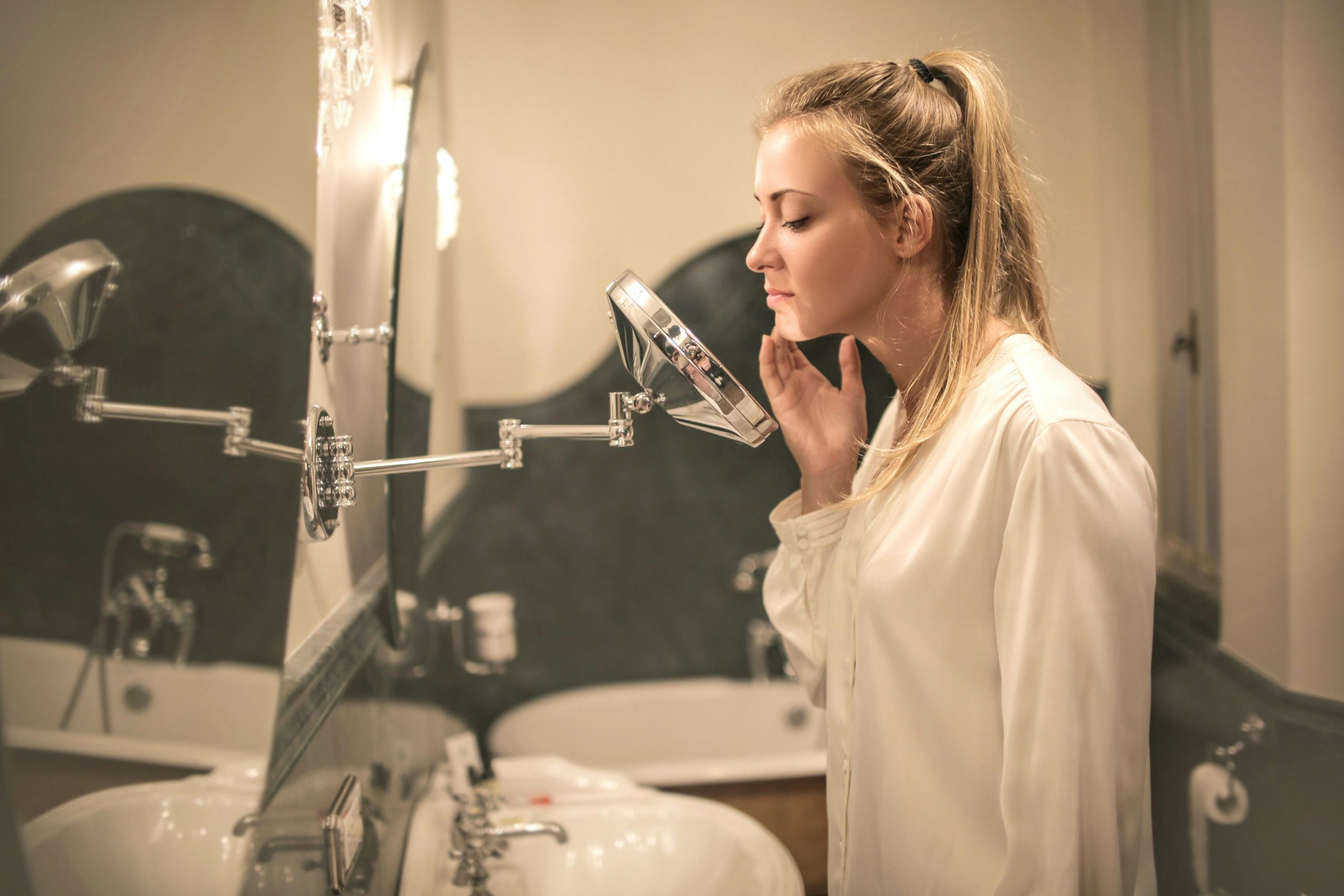 Woman looking at her acne in the mirror