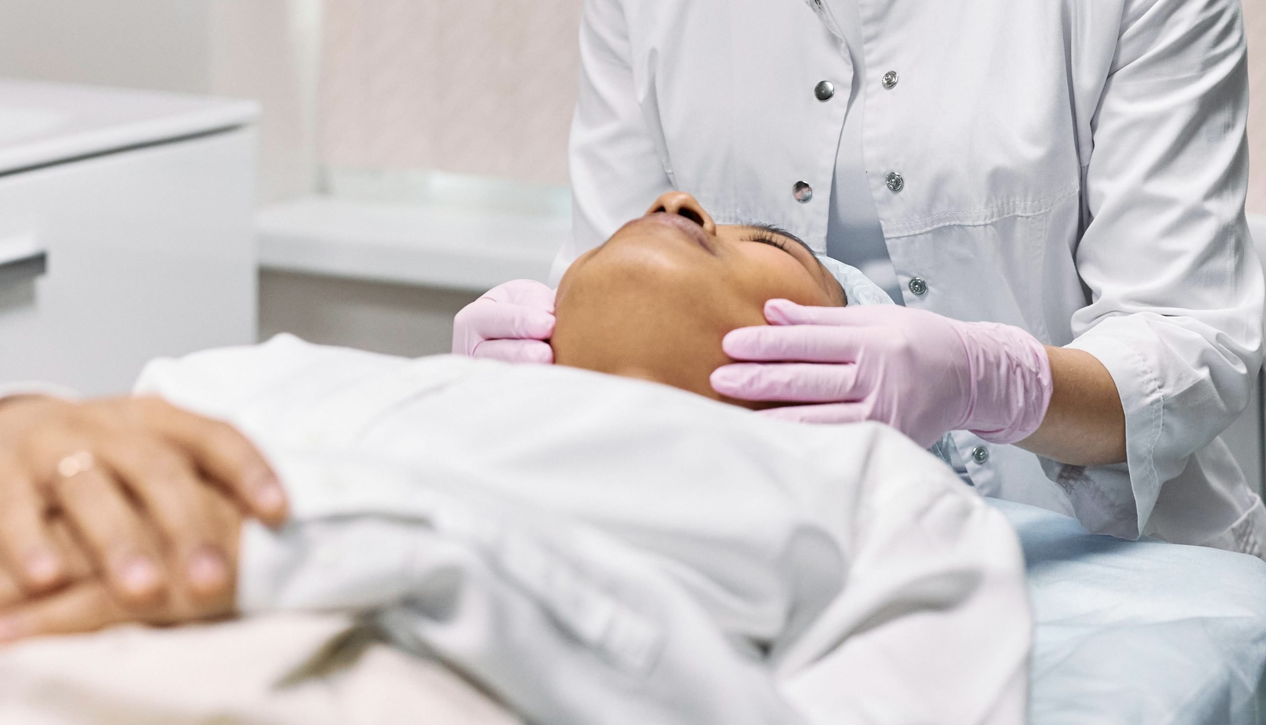 Skin consultation with a skin specialist in winnipeg Skin specialist winnipeg examining a client'