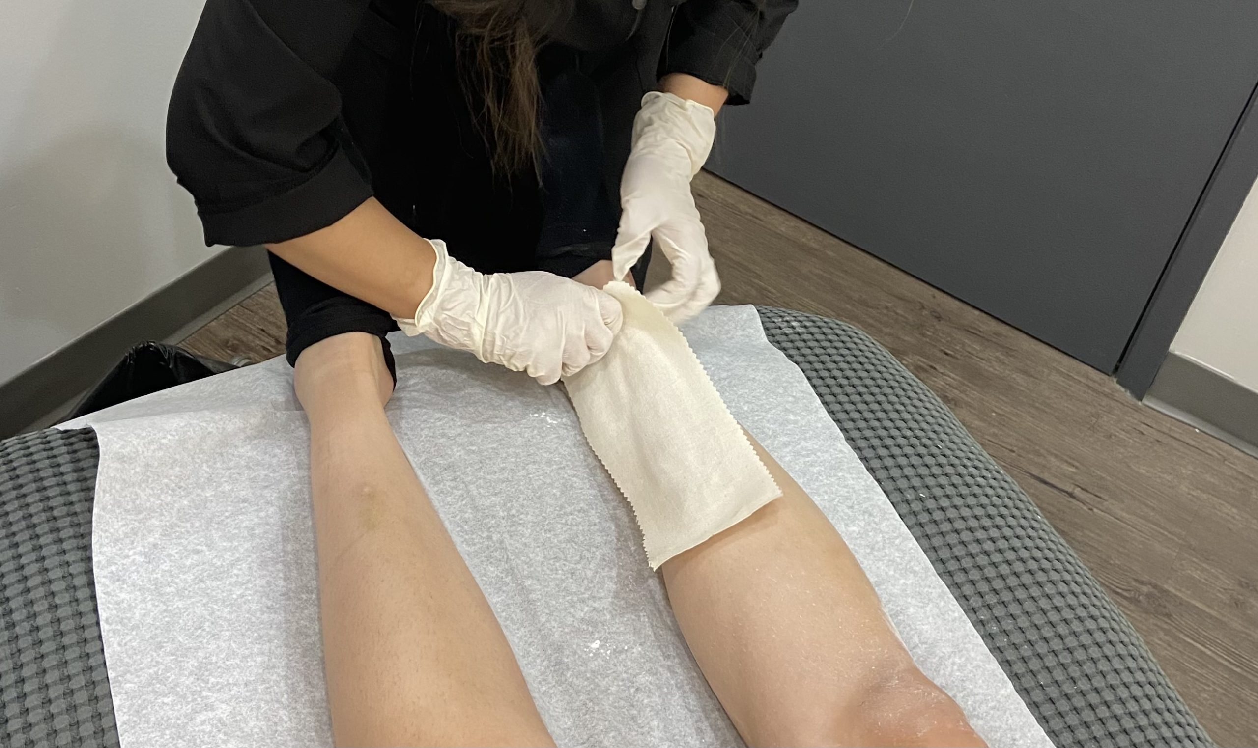 headingley waxing client leg wax Esthetician applying wax to a client’s leg during a Headingley waxing appointment in Winnipeg