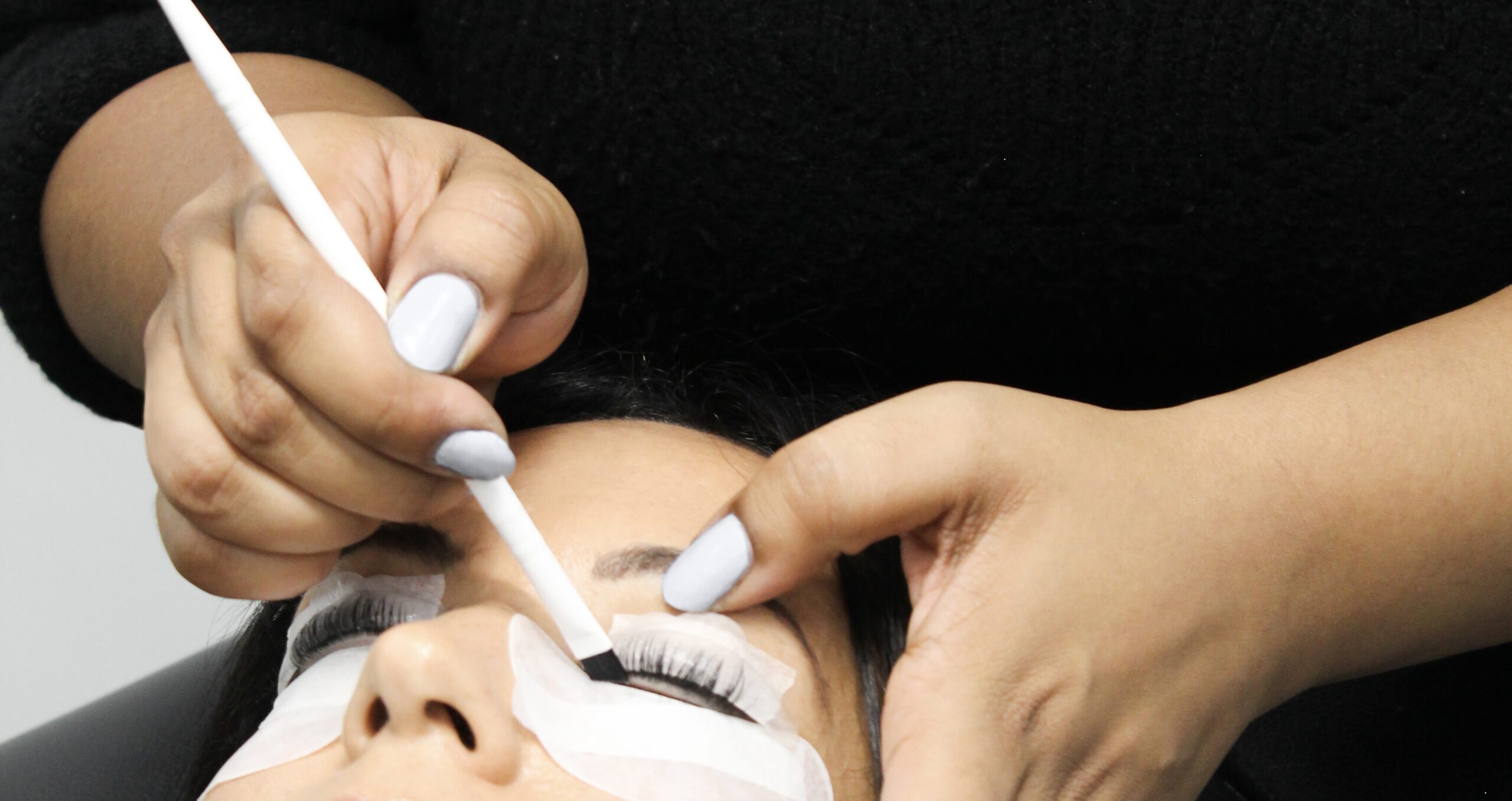 esthetician peforming a lash lift in winnipeg