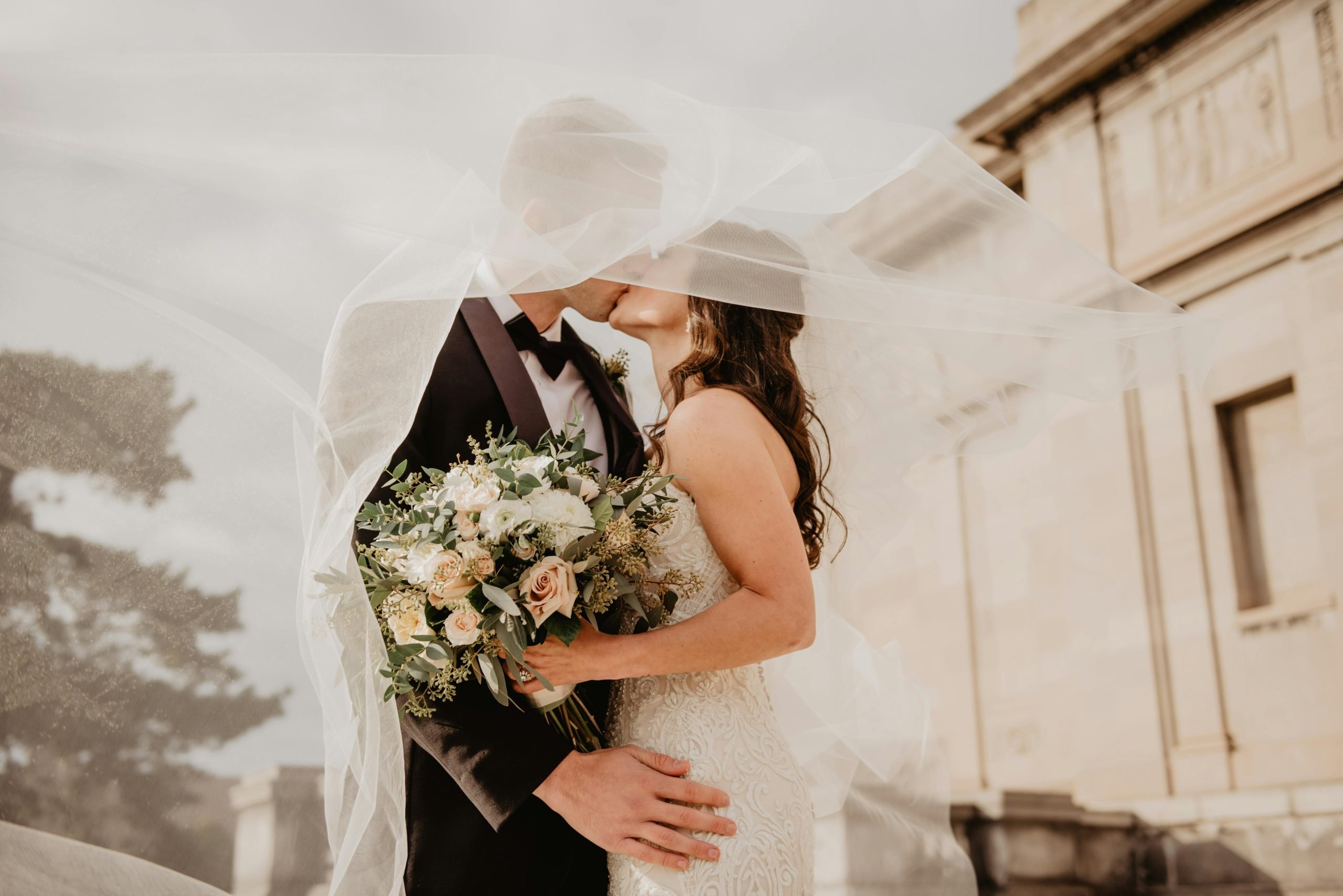 Bride and groom kissing, their smooth and glowing skin a result of a laser facial in Winnipeg before the big day.